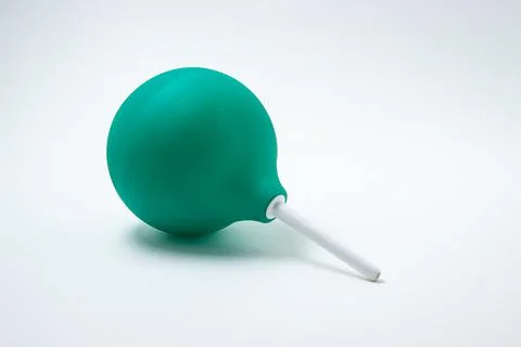 Green enema on a white background. Constipation treatment. Stock Photos