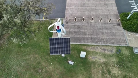 A green energy integrated system using a hybrid wind turbine and solar panel to Stock Footage 325478898