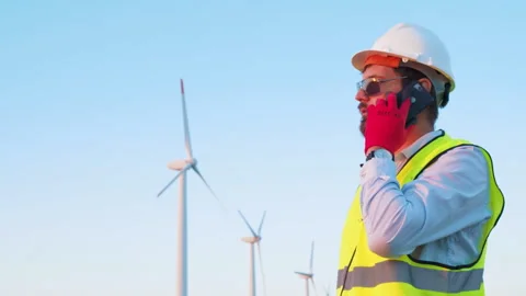 Green energy power engineer inspector is talking on the phone in the wind park. Stock Footage 246380358