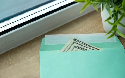 A green envelope with a dollar bill inside Stock Photos