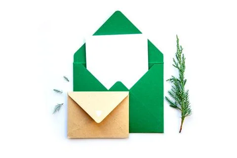A green envelope sits open with a blank letter inside, accompanied by sprigs  Stock Photos