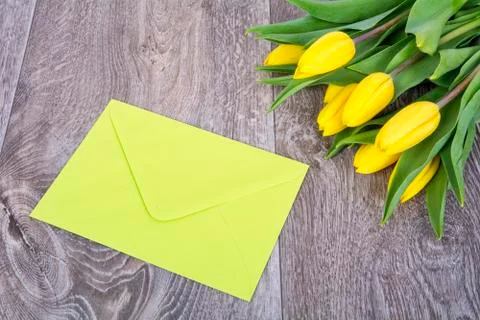 Green envelope with tulips on a table 스톡 사진