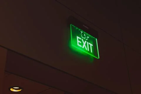 Green Exit sign on dark background Stock Photos