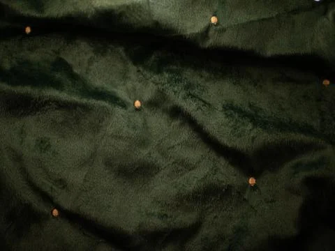 A green fabric with a pattern of small dots Stock Photos