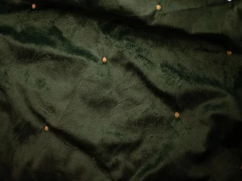 A green fabric with a pattern of small dots Stock Photos