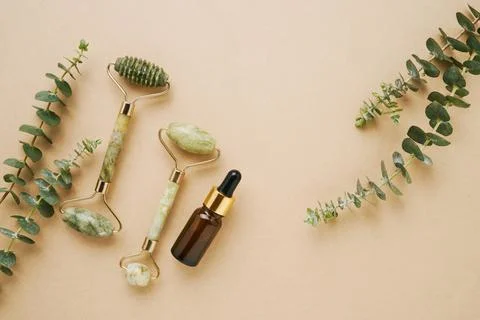 Green face jade roller, dark brown glass dropper bottle for medical and cosme Stock Photos