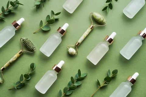 Green face jade rollers, white glass dropper bottles for medical and cosmetic Foto stock