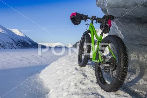 Green Fatbike 907 Whiteout bike resting on giant iceberg in winter on Portage La Stock Photos