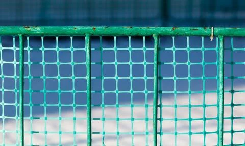A green fence with a mesh pattern Stock Photos