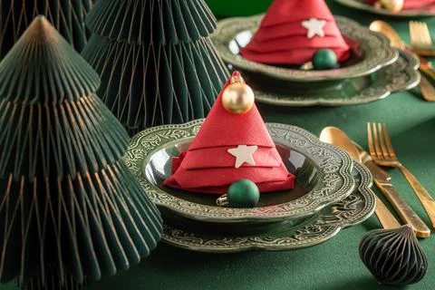 Green festive table setup adorned with baubles. Stock Photos
