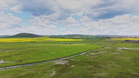 Green field with clouds over a rural landscape in springtime Video stock 338240346