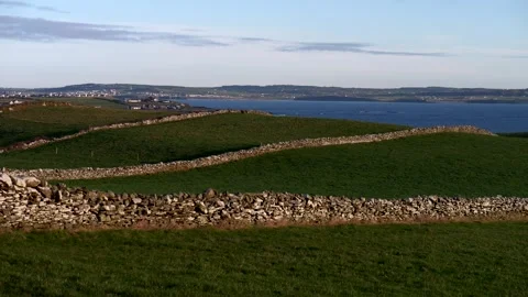 Green field of grass with stone barriers. Wild Atlantic coast. Video 4K Видео 330477084
