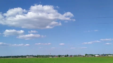 Green field with moving white clouds on a blue sky. time lapse video Stock Footage 156750923