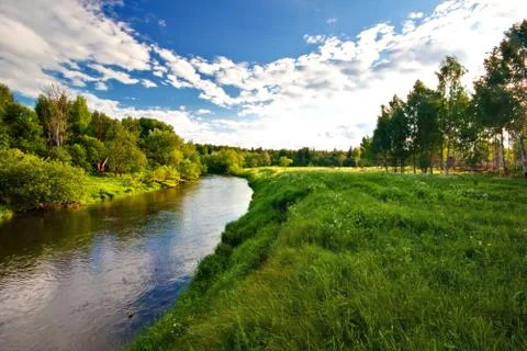 Green field with small river Stock Photos