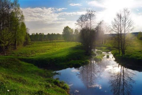 Green field with small river Stock Photos