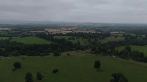 A green field with trees and a cloudy sky Stock Footage 328536344