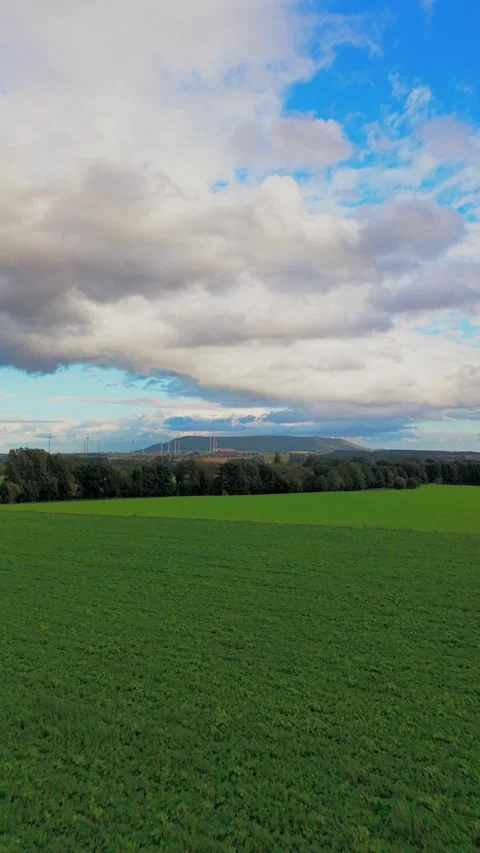Green Field Under Cloudy Sky With Wind Turbines Stock Footage 345113593