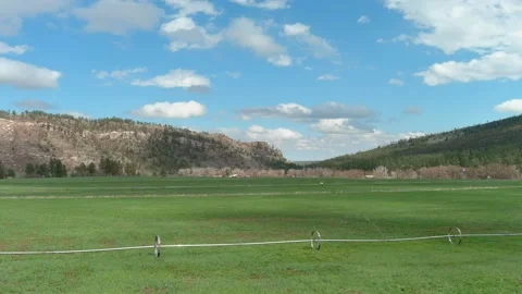 Green fields and blue sky in Colorado mountain valley Stock Footage 153780677