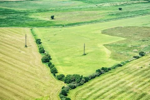 Green fields and high voltage power lines, view from airplane Stock Photos