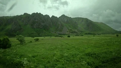 Green fields and small cultivated plot with jagged mountains in Andoya Norway 库存影片 343131190