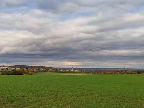 Green fields contrast with gray clouds above Kutna hora St. Barbaras church Stock Photos