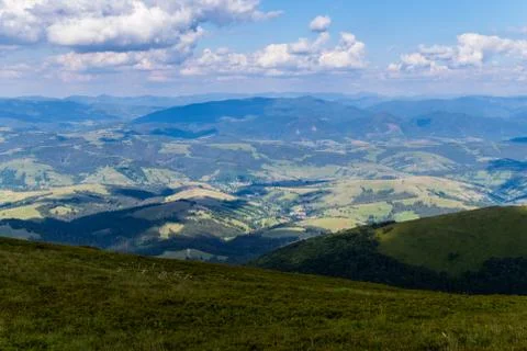 Green fields, deciduous forests and a small rural village at the foot of the  Stock Photos