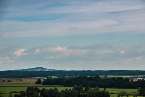 Green fields, green meadows, dark forests and the cloudy sky Stock Photos