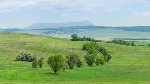 Green fields, hills and mountains in distance Stock Footage 76468261