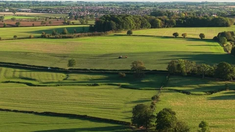 Green fields, layered meadows, rolling rural farmland stretching across wide Video stock 333580252