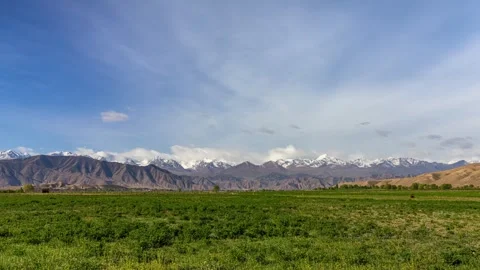 Green fields with mountains and red canyon near Issyk Kul Lake. Stock Footage 265058924