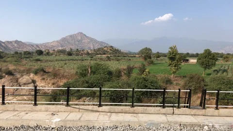 Green fields, power lines, labourer and workers shanties and mountains Stock Footage 124331408