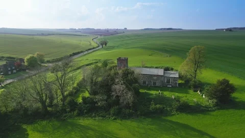 Green fields stretch under a bright blue sky 스톡 동영상 346855570