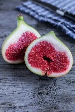 A green fig cut in half on rustic background Stock Photos