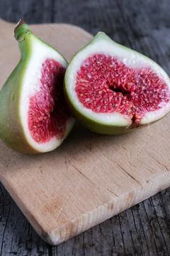 A green fig cut in half on rustic background Stock Photos