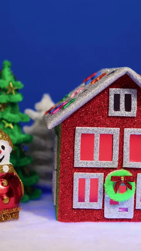Green fir trees and two snowmen near a red and green house Stock Footage 299542918