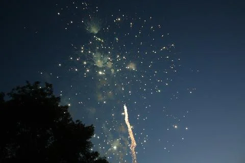 Green fireworks sparks bursting in the twilight sky Stock Photos
