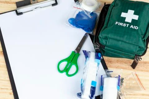 Green first aid kit on a table with a clipboard 스톡 사진