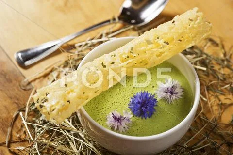 Green foam suit with mountain cheese, a wafer and cornflowers Stock Photos