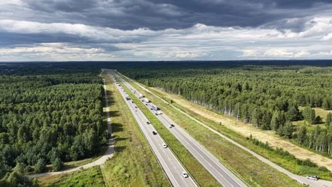 Green forest highway seen from above with passing vehicles Stock Footage 348388161