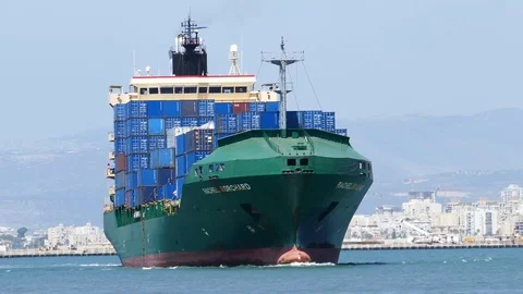Green freight ship with blue containers sails 4k intro video for business Stock Footage 94555648