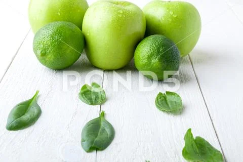 Green fruits on white wooden background. Apple, lime, spinach. Detox. Healthy Stock Photos