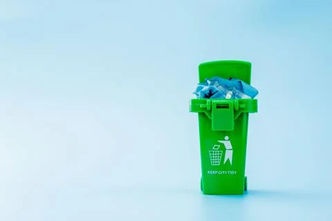 Green garbage, trash bin on blue background Stock Photos