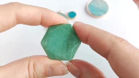 Green gemstone pendant featuring hexagonal faceted crystal shapes Stock Footage 345139611