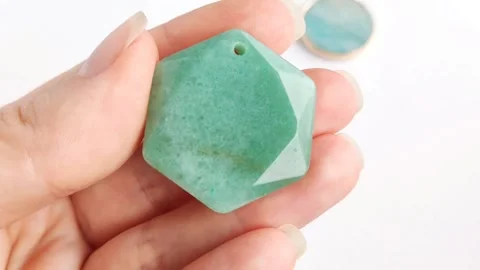 Green gemstone pendant featuring hexagonal faceted crystal shapes Stock Footage 345139627