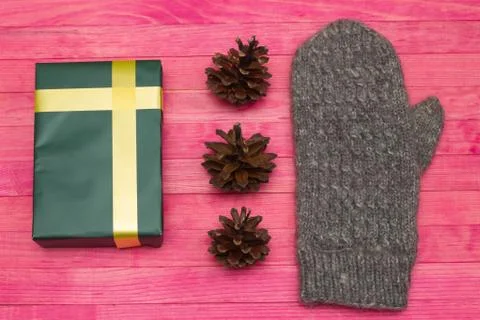 Green gift box and pine cone with mitten Foto stock
