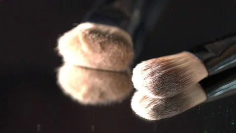 Green glitter falling on the makeup brushes on the mirror on the black Stock Footage 75972327