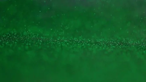 The green glitter falls to the surface. Stock Footage 77581481