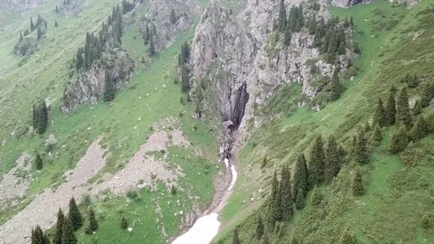 Green gorge. Beautiful cliffs and mountains. Runs a small waterfall and a river. Video stock 100771031