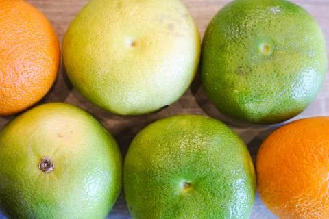 Green grapefruit and oranges background fruits vitamin C season citrus healthy Stock Photos