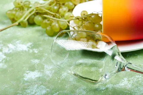 Green grapes with an empty wine glass around Stock Photos